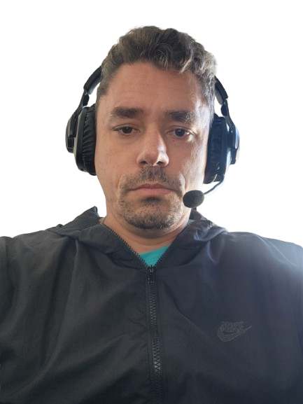 Uma foto do autor do deste site. Auto descrição: Um homem branco de cabelo curto castalho escuro, olhos castanho claro, usando um fone de ouvido da marca JBL com microfone, usando uma blusa corta vento preta.